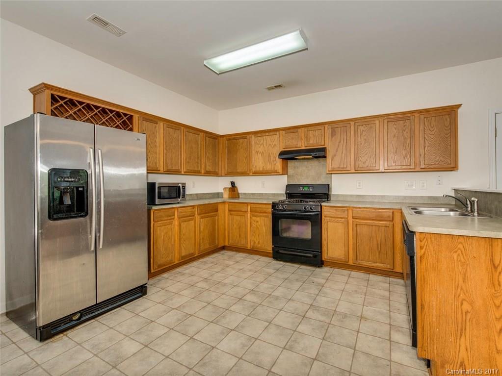 932 Garrison Road Charlotte, NC 28262 - Photo 6 of 20 a kitchen with granite countertop a refrigerator sink and cabinets