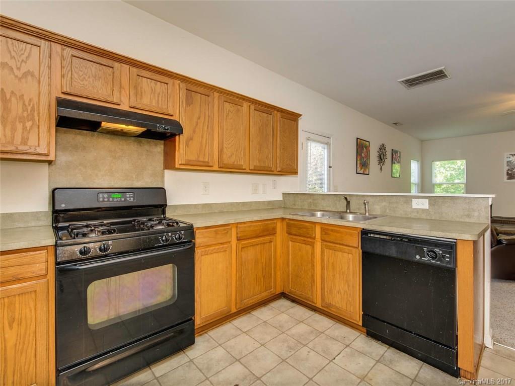 932 Garrison Road Charlotte, NC 28262 - Photo 7 of 20 a kitchen with granite countertop a stove top oven sink and cabinets