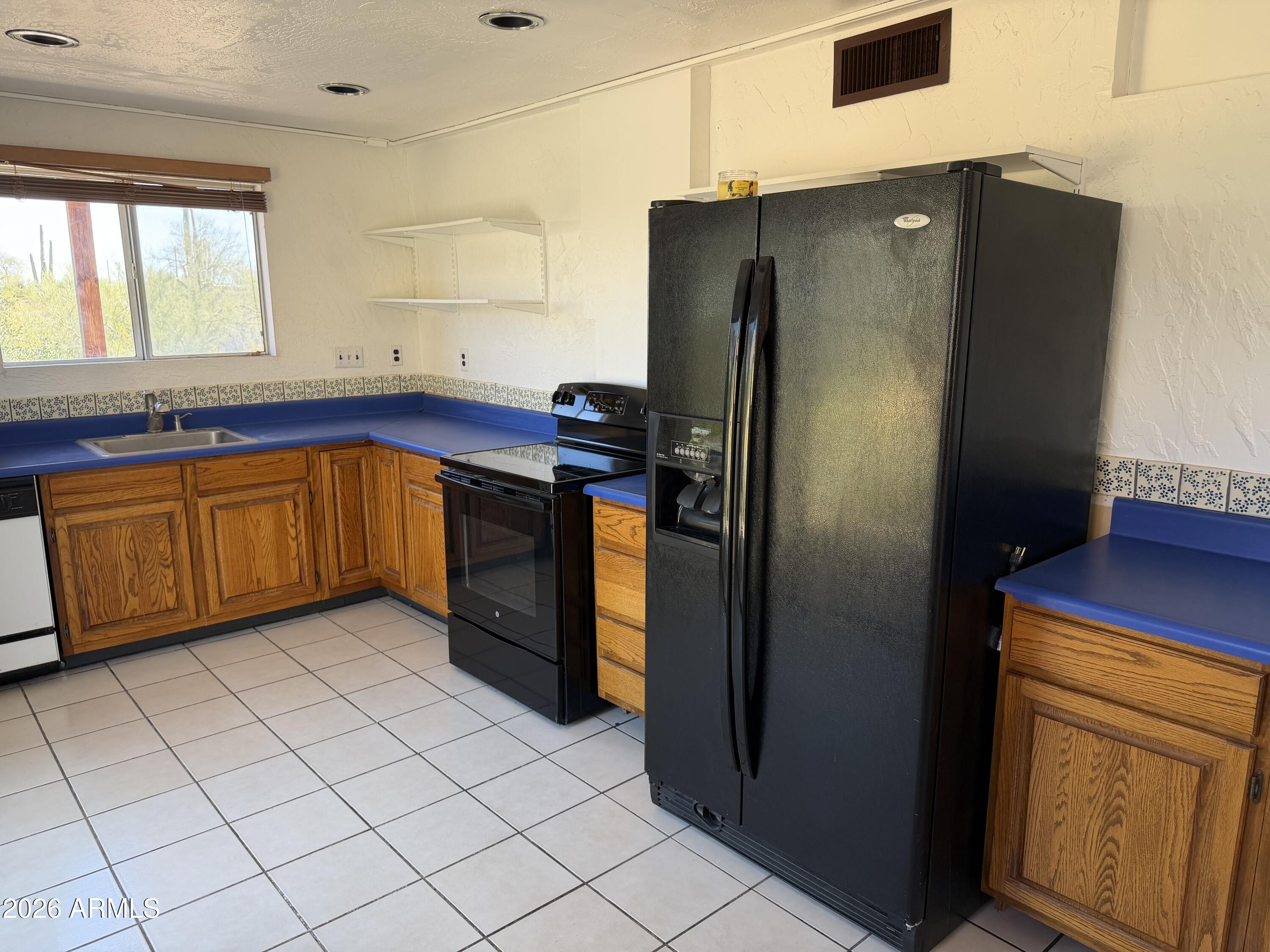 1315 North Arroya Road Apache Junction, AZ 85119 - Photo 10 of 24 a kitchen with stainless steel appliances granite countertop a refrigerator and a sink