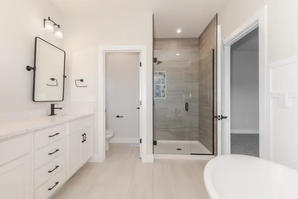 a bathroom with a shower tub double vanity sink and mirror