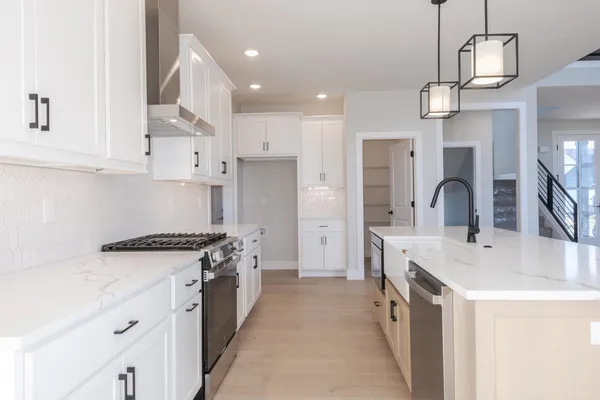 a kitchen with stainless steel appliances granite countertop a sink stove and refrigerator