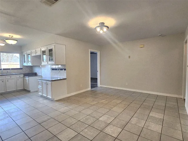 a view of kitchen with cabinets and window