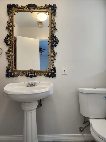 a bathroom with a sink toilet and mirror