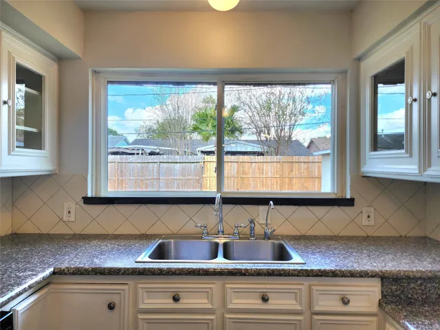 a kitchen with granite countertop a stove window and cabinets
