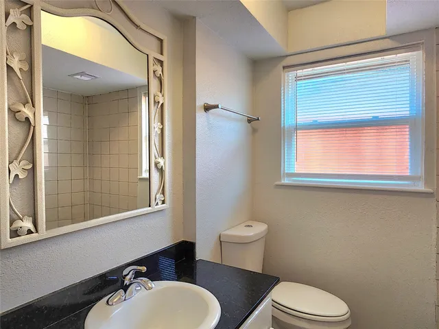 a bathroom with a toilet a sink and mirror