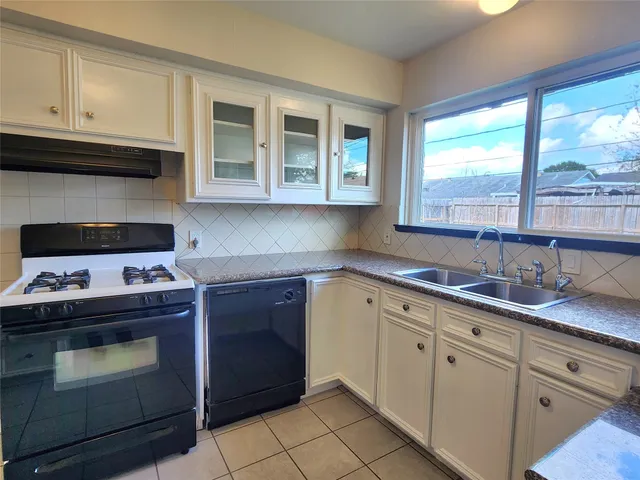 a kitchen with cabinets appliances and a window