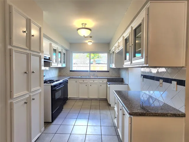 a kitchen with stainless steel appliances granite countertop a sink and a stove