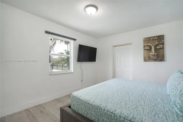 a bedroom with a bed and a flat screen tv