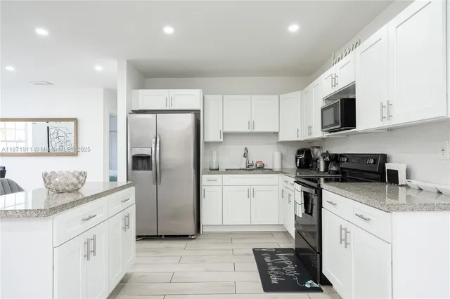 a kitchen with a refrigerator stove microwave and sink
