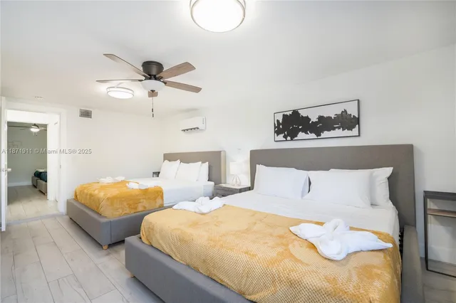 a bedroom with two beds and painting on the wall