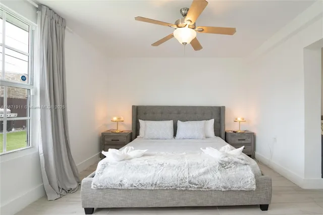 a large bed sitting in a bedroom next to a window