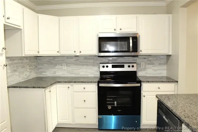 a kitchen with granite countertop a stove and a microwave