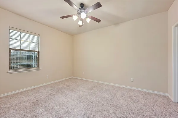 a view of an empty room with a chandelier fan