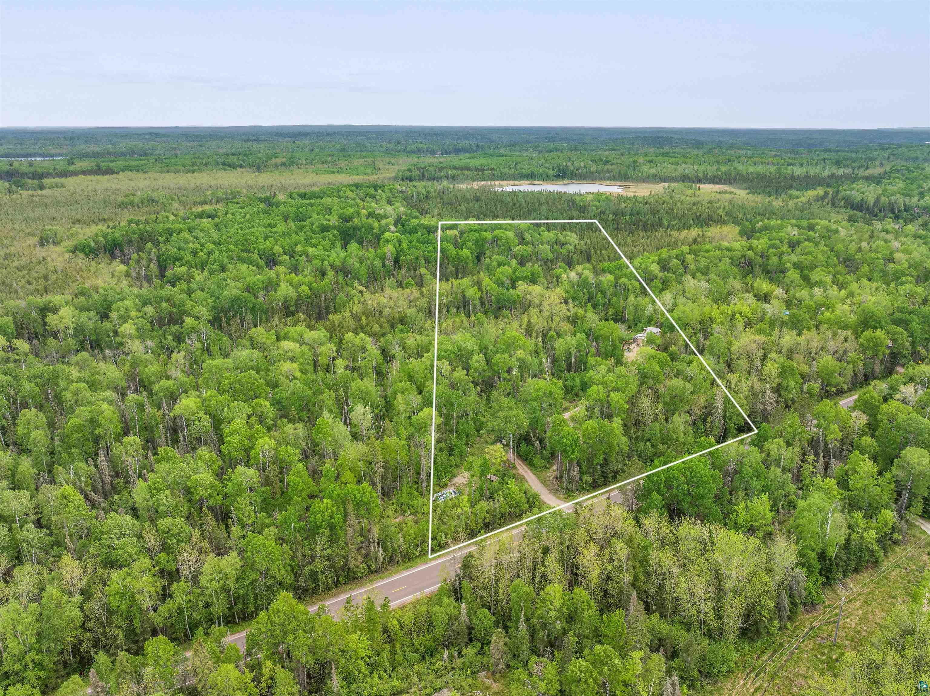 1152 Fernberg Road Ely, MN 55731 - Photo 3 of 24 Expansive wooded parcel featuring mature trees, a defined property boundary, and direct road frontage