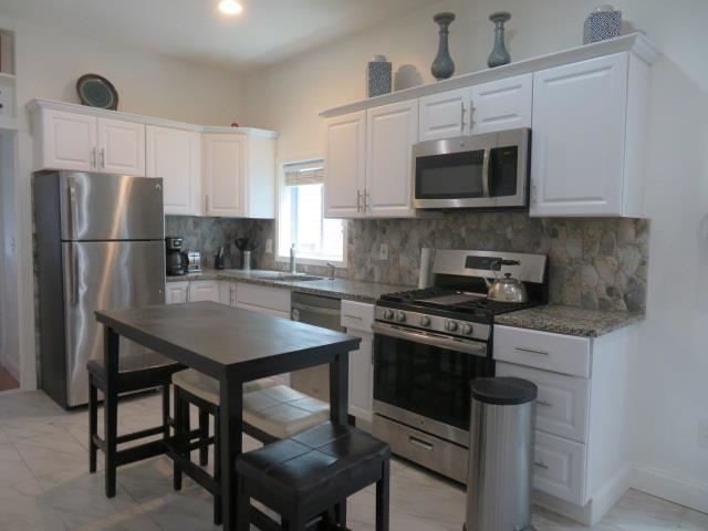a kitchen with stainless steel appliances a stove a sink microwave and cabinets