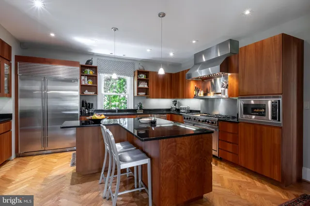 a kitchen with stainless steel appliances granite countertop a sink a stove a refrigerator and island