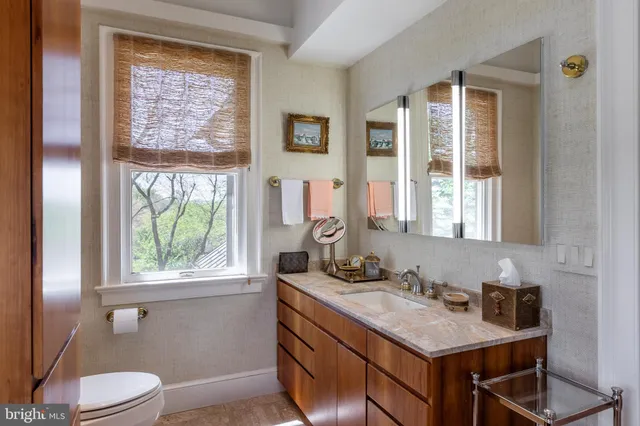 a bathroom with a sink a toilet and a window