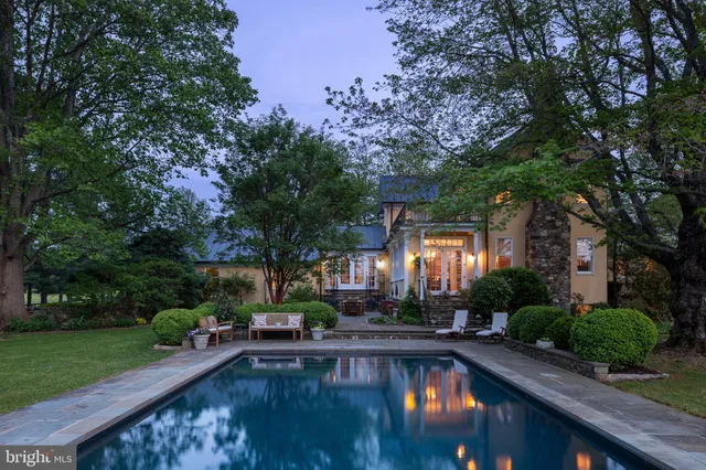 a swimming pool view with a seating space and a garden