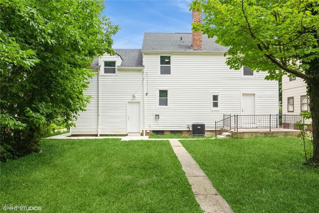 2188 North Taylor Road Cleveland Heights, OH 44112 - Photo 2 of 15 Rear view of house featuring roof with shingles, a yard, and a chimney