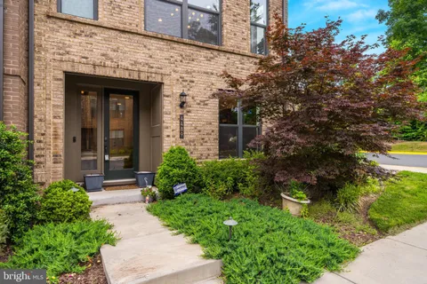 a kitchen with stainless steel appliances kitchen island granite countertop lots of wooden cabinets a dining table and chairs