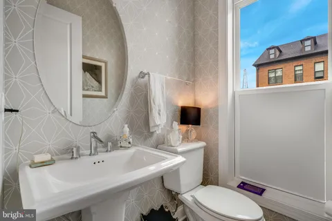 a bathroom with a sink toilet and mirror