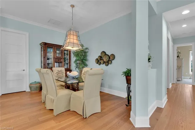 a dining room with furniture wooden floor mirror and a chandelier