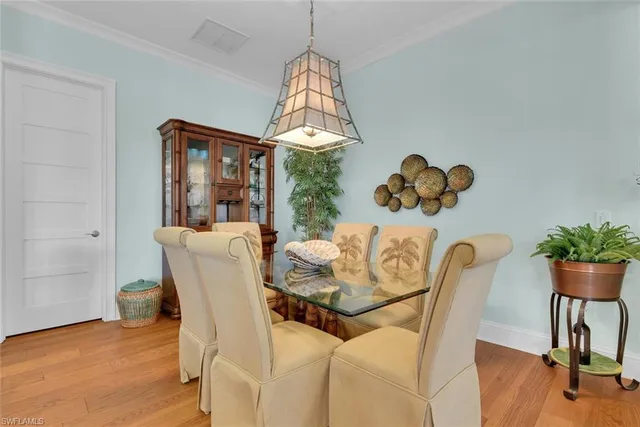 a dining room with furniture potted plants and wooden floor