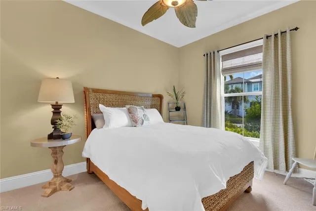 a bed sitting in a bedroom next to a window and a chandelier