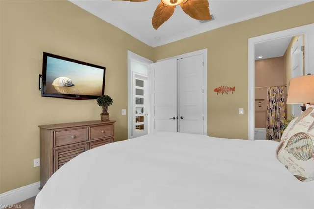 a bedroom with a bed and a flat tv screen on dresser