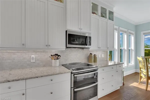 a kitchen with granite countertop white cabinets and appliances