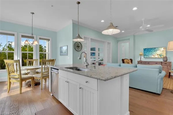 a view of a kitchen counter space a sink wooden floor and living room view