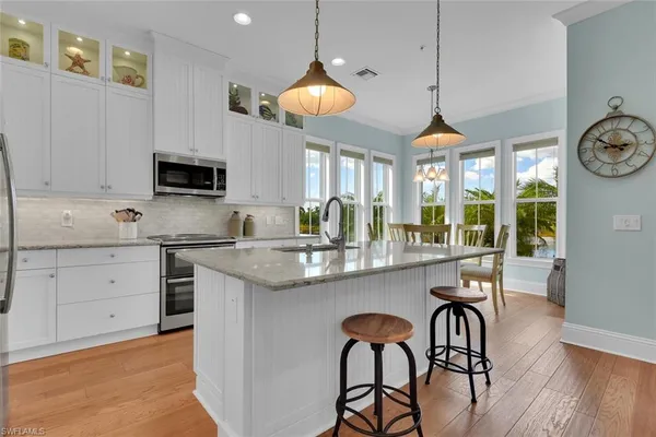 a kitchen with stainless steel appliances granite countertop a stove and a wooden floor