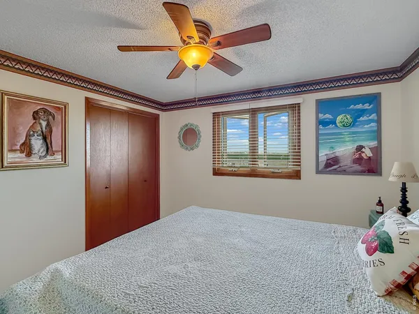a bedroom with bed and ceiling fan
