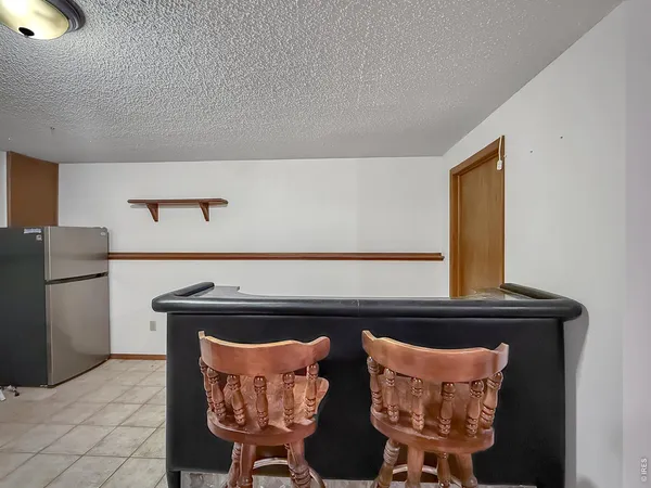 a bed sitting in a bedroom next to a window with pc on the wall