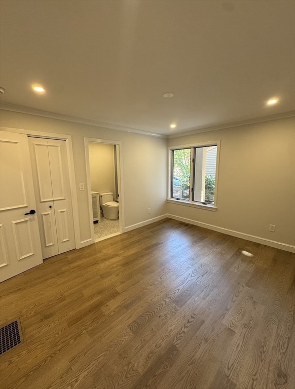 7 Wainwright Road, Unit 13 Winchester, MA 01890 - Photo 19 of 24 an empty room with wooden floor and windows