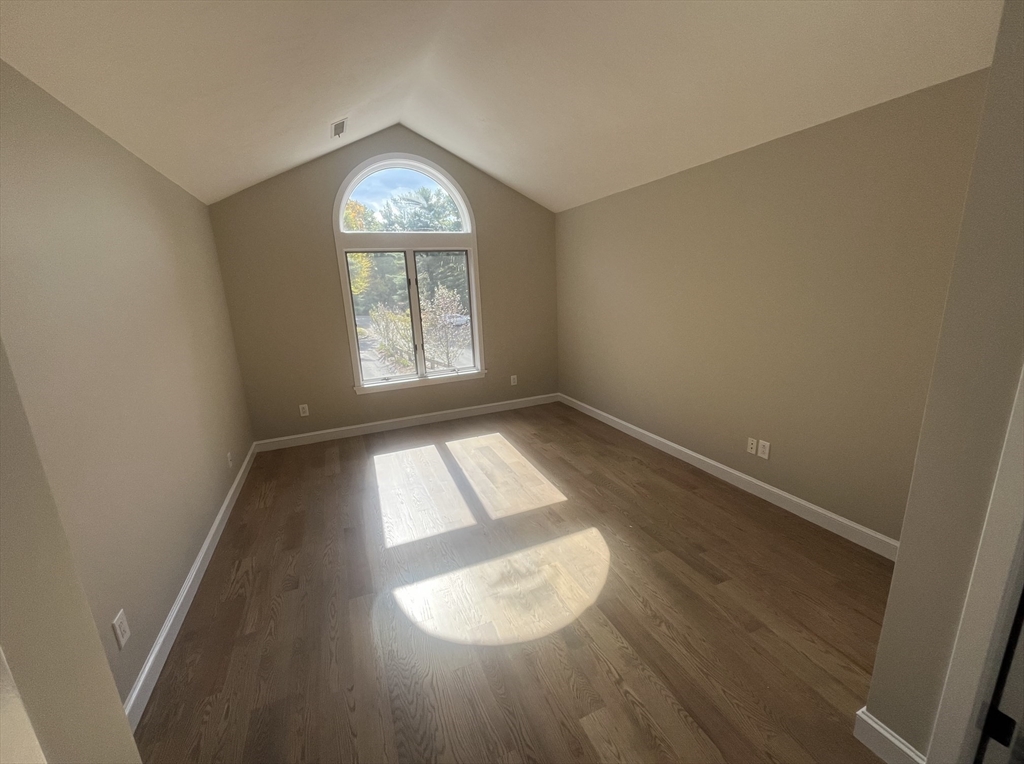 7 Wainwright Road, Unit 13 Winchester, MA 01890 - Photo 21 of 24 an empty room with wooden floor and windows