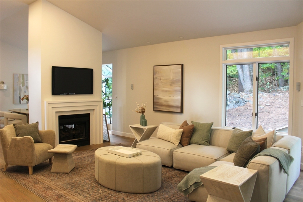 7 Wainwright Road, Unit 13 Winchester, MA 01890 - Photo 7 of 24 a living room with furniture a fireplace and a flat screen tv