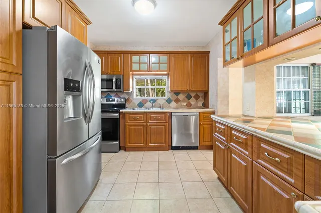 a kitchen with stainless steel appliances granite countertop a refrigerator a sink a stove and washer