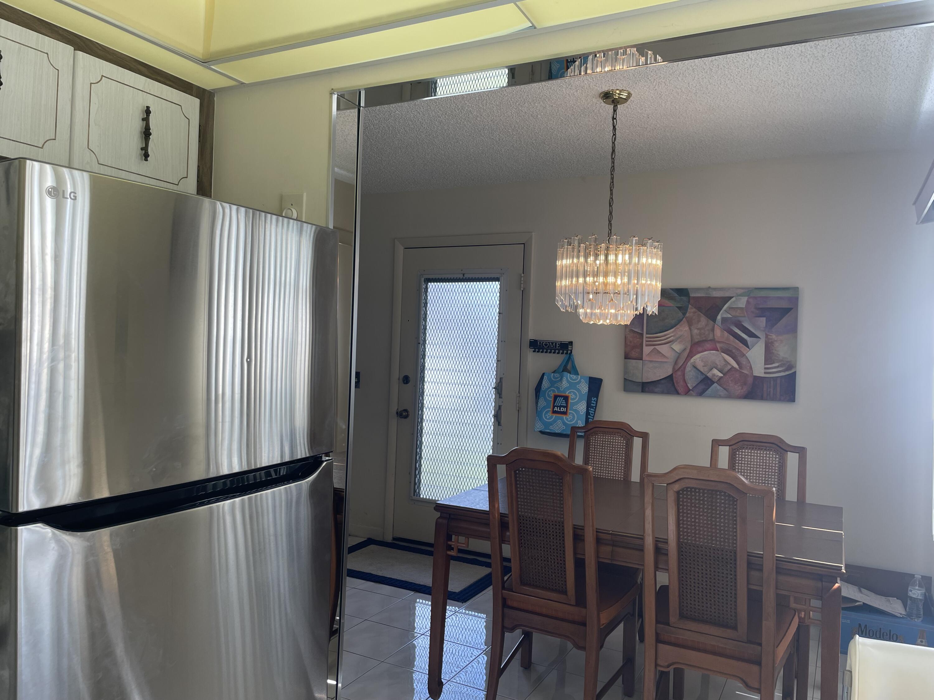 705 Normandy Lane, Unit 705 Delray Beach, FL 33484 - Photo 13 of 37 a view of a dining room with furniture window and wooden floor