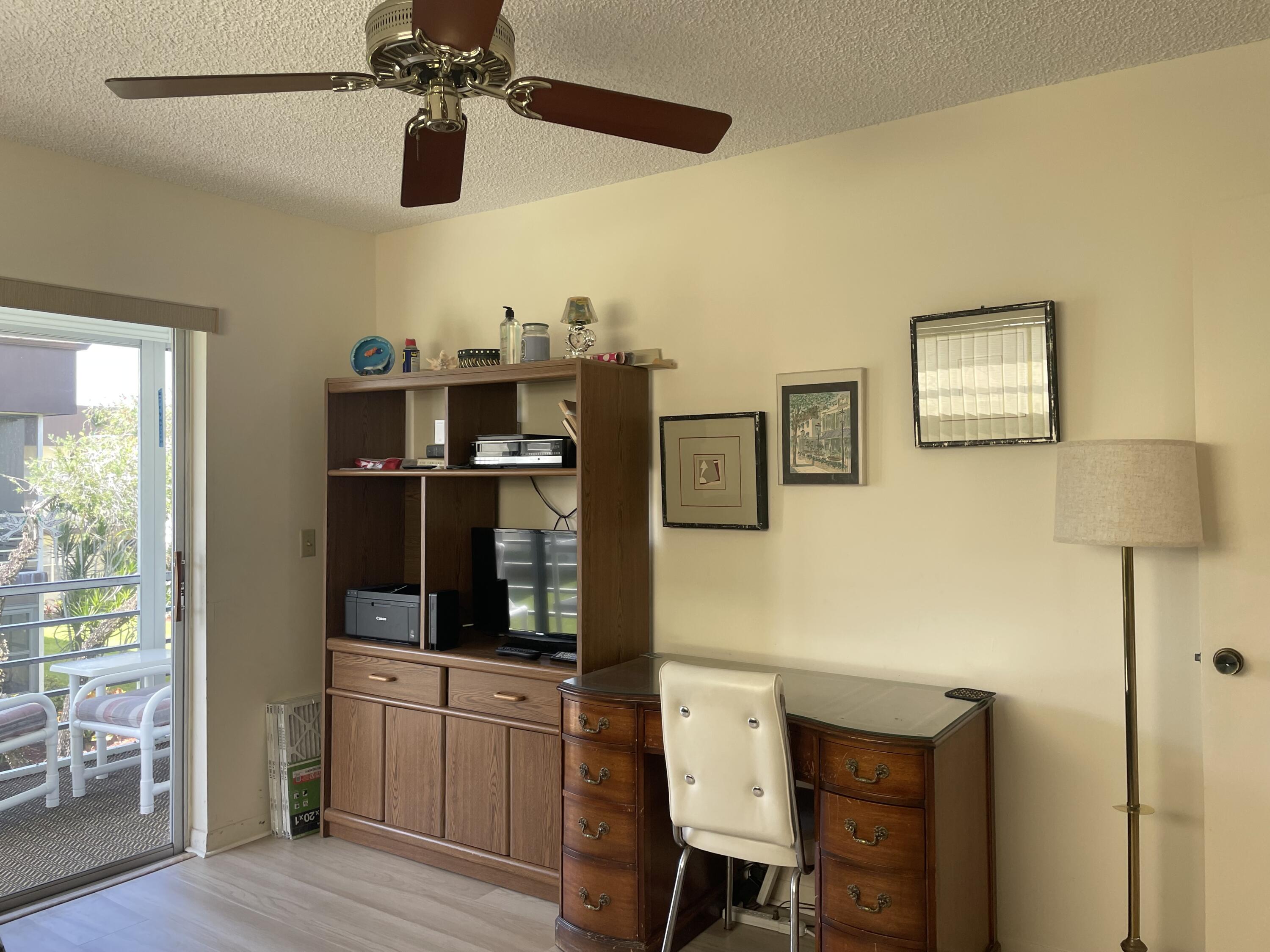 705 Normandy Lane, Unit 705 Delray Beach, FL 33484 - Photo 20 of 37 a kitchen with stainless steel appliances kitchen island granite countertop a refrigerator a stove a dining table and chairs with wooden floor
