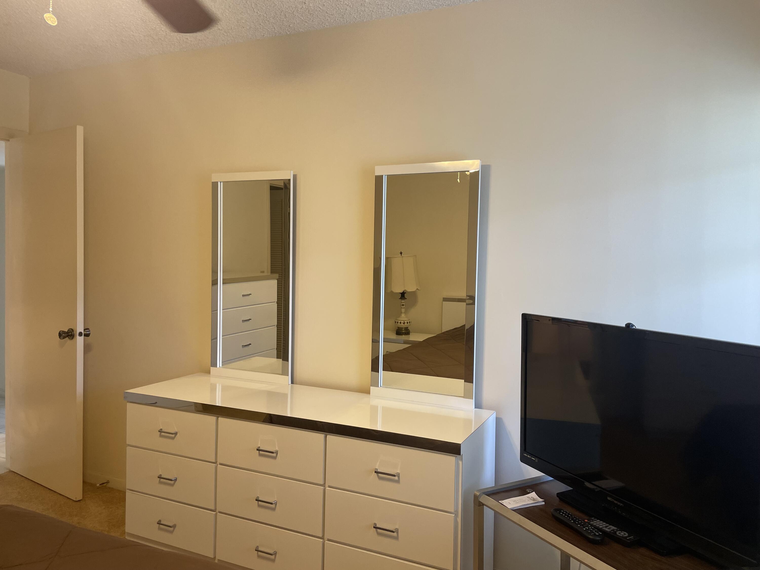 705 Normandy Lane, Unit 705 Delray Beach, FL 33484 - Photo 32 of 37 a bathroom with a double vanity sink and mirror