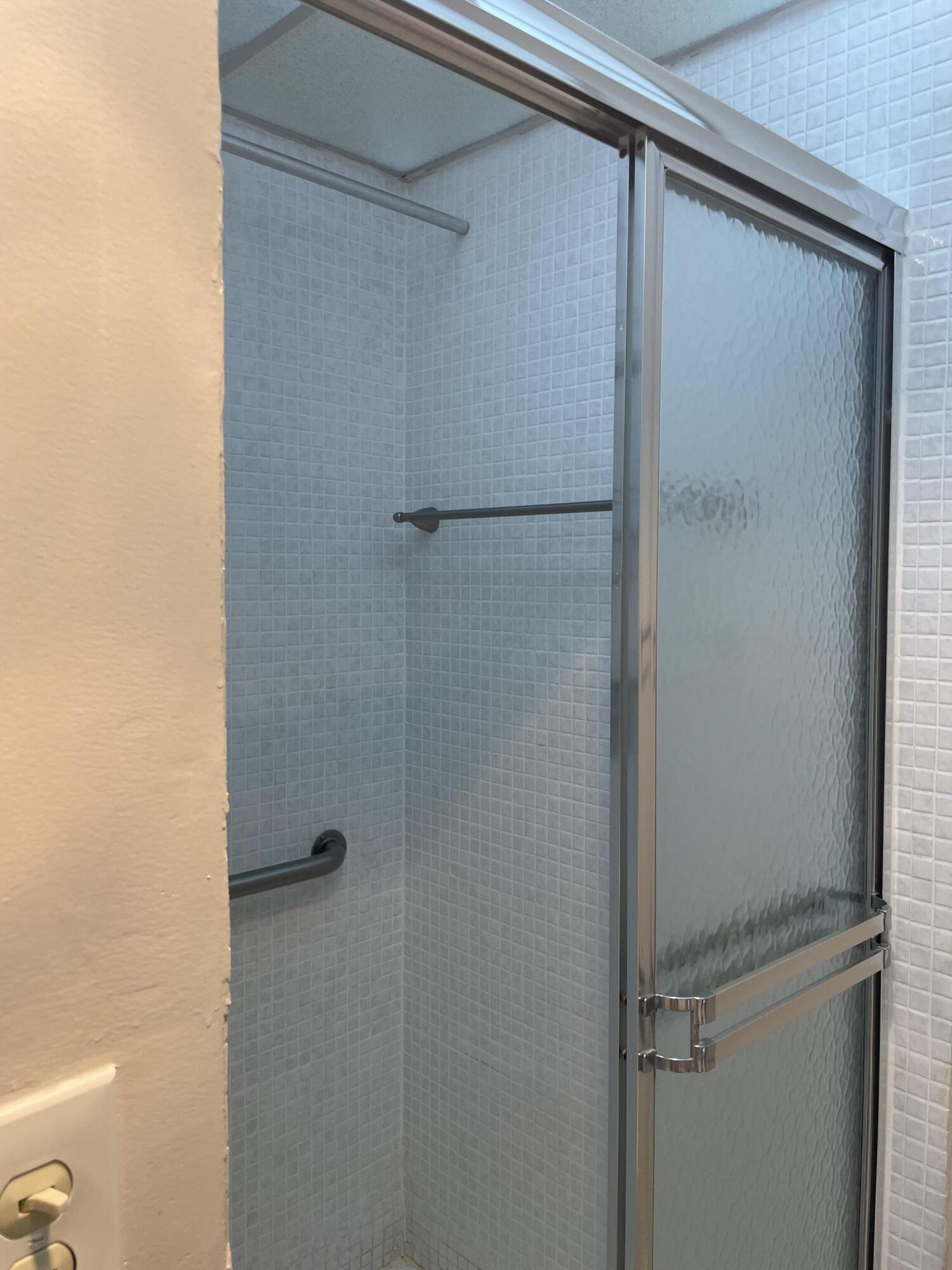 705 Normandy Lane, Unit 705 Delray Beach, FL 33484 - Photo 35 of 37 a bathroom with a glass door shower