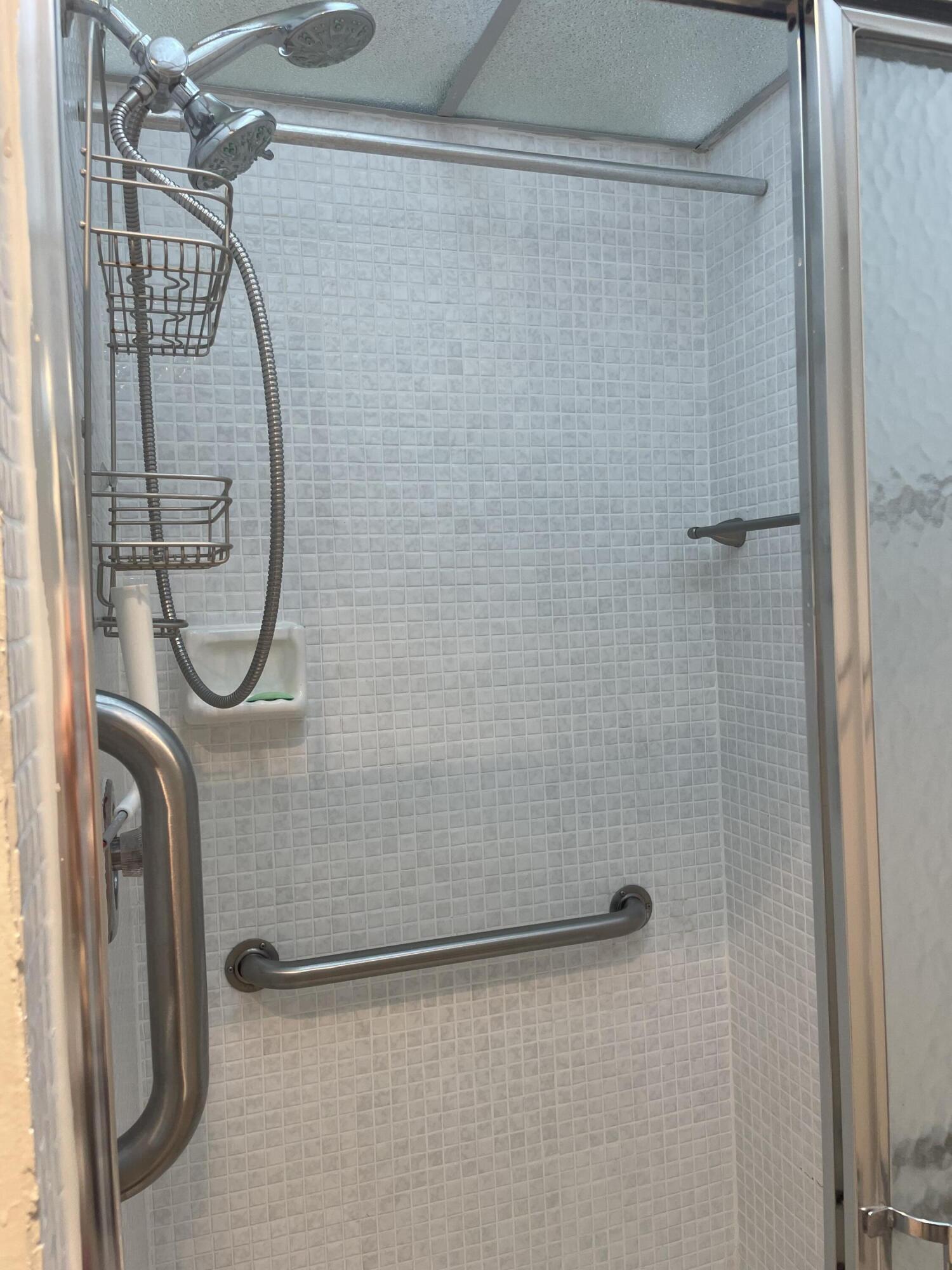 705 Normandy Lane, Unit 705 Delray Beach, FL 33484 - Photo 36 of 37 a bathroom with a shower and a mirror