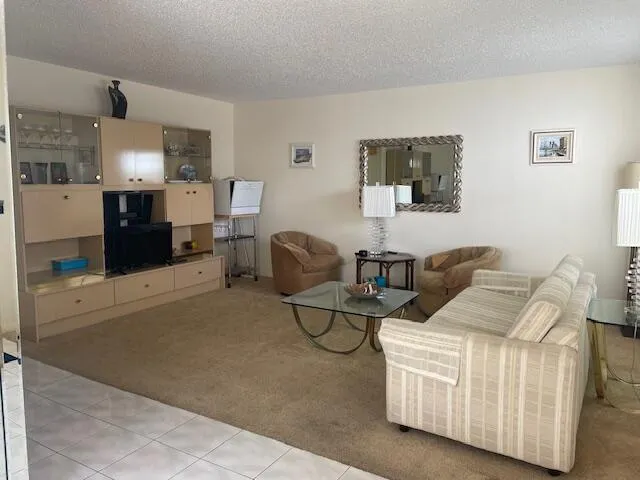 a living room with furniture and a view of kitchen