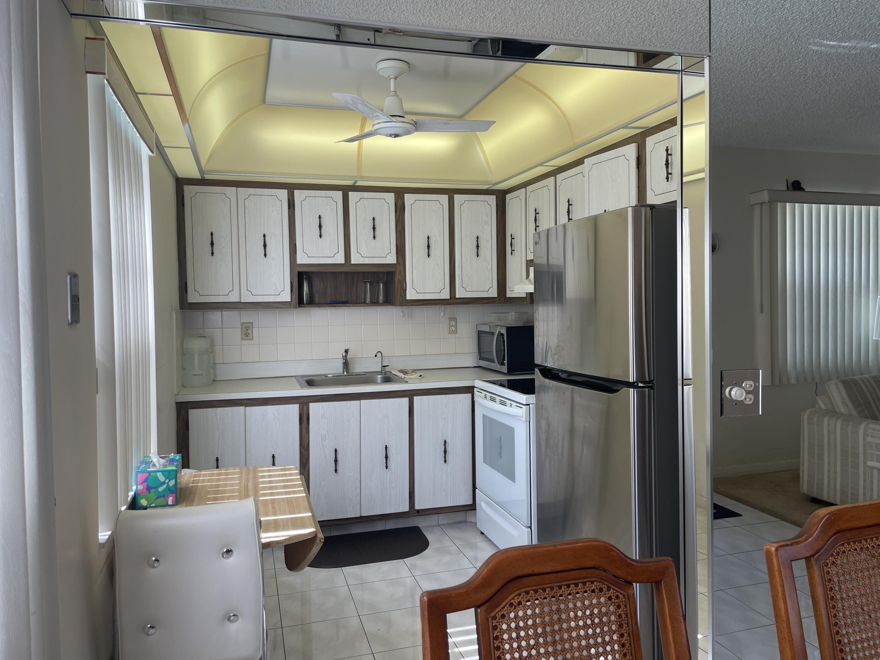 705 Normandy Lane, Unit 705 Delray Beach, FL 33484 - Photo 10 of 37 a kitchen with stainless steel appliances granite countertop a refrigerator a sink and a stove