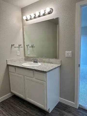 a bathroom with a granite countertop sink and a mirror