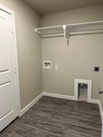 a view of a room with wooden floor and a window