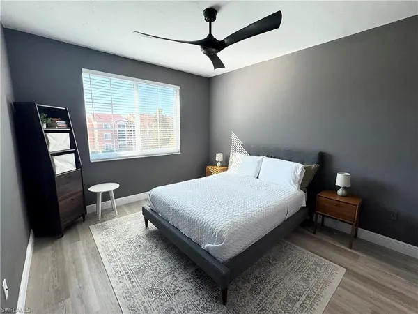 a bedroom with a bed a dresser and window