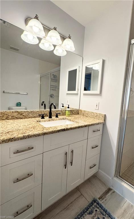 1190 Reserve Way, Unit 304 Naples, FL 34105 - Photo 17 of 20 a bathroom with a granite countertop sink and a mirror