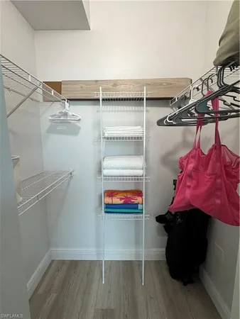 a utility room with dryer and hardwood